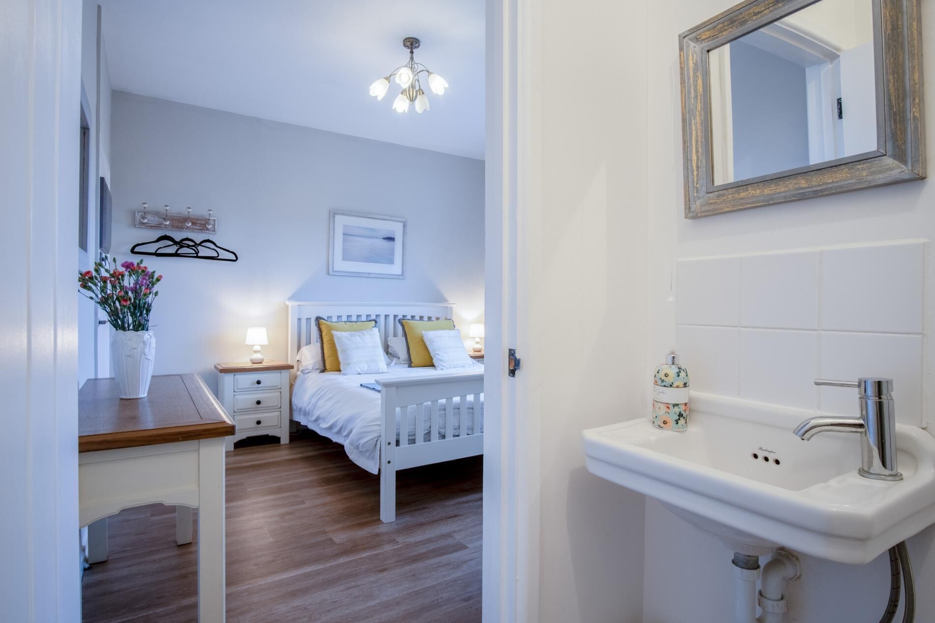 Une chambre à coucher avec un lit, une table de chevet, une lampe et un luminaire suspendu.
