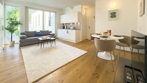 A modern apartment with a living room, dining area, and kitchen. - Hillside Living Vienna (Vienna)