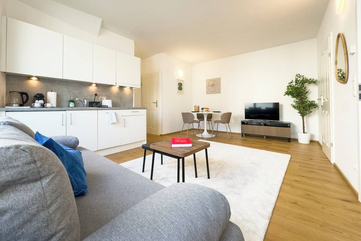 Un appartement moderne comprenant une cuisine, un coin repas et un salon.