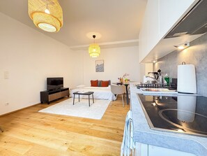 A modern apartment with a living area, kitchenette, and a dining space. - Hillside Living Vienna (Vienna)