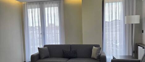 Una sala de estar moderna con un sofá, una mesa de centro y una lámpara.