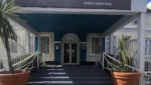 The London Croydon Hotel entrance with a covered walkway, potted plants, and a clear blue sky. - London Croydon Hotel (Thornton Heath)