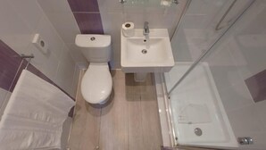 A modern bathroom with a toilet, sink, and shower. - London Croydon Hotel (Thornton Heath)