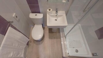 Un baño moderno con inodoro, lavamanos y ducha.