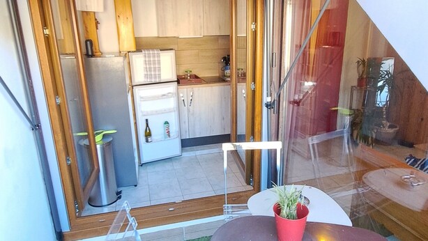 Un pequeño patio con mesa, sillas y un tendedero.
