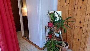 Esquina de una habitación con pared de madera, una puerta blanca y una cortina roja.
