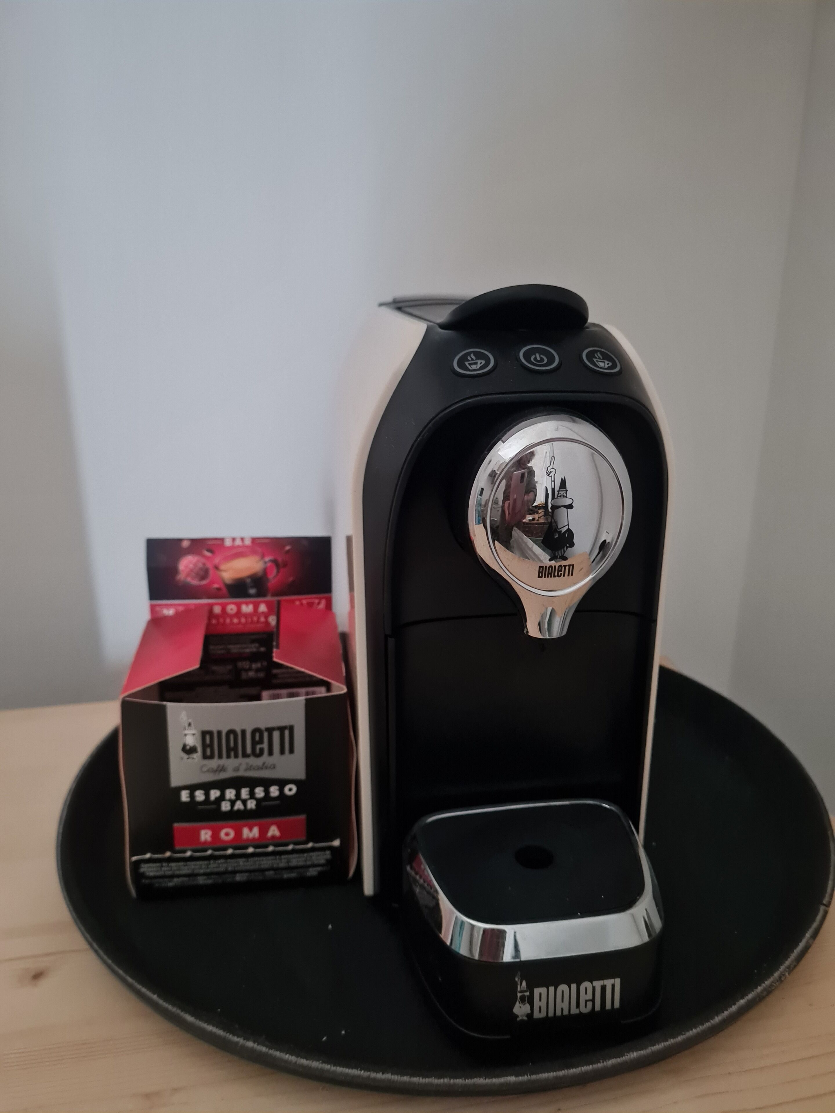 A Bialetti espresso machine with a branded coffee pod box and a base.