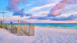 A sandy beach with a wooden fence and sparse vegetation. - Beachfront- Amazing Views-Lighthouse 310 (Gulf Shores)