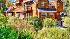 A large wooden house with multiple levels, a balcony, and a chimney. - Spacious Family Cabin w/Hot Tub & Mountain Views (Tehachapi)