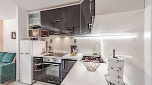 Una cucina compatta con frigorifero, forno e lavandino.