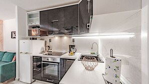 A compact kitchen with a refrigerator, oven, and sink. - Villa Anna by Villas Guide (Vela Luka)