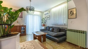 Ein Wohnzimmer mit einer Couch, einem Couchtisch, einer Topfpflanze und einer Heizung.
