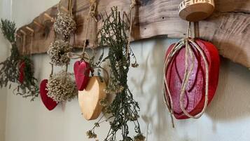 Un élément de décoration murale de style rustique, avec des éléments en bois et en rouge, notamment une cloche et des objets en forme de cœur.