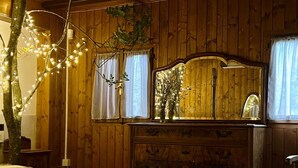 Una stanza in legno con un letto, una cassettiera e uno specchio.
