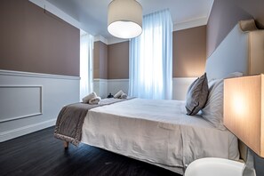 A hotel room with a large bed, a bedside table, a lamp, a window with curtains, and a ceiling light. - Garibaldi Palace The Chic Luxury loft (Prato)