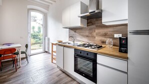 A modern kitchen with a wooden countertop, stainless steel appliances, and a view to the outside. - YiD quiet 2BR apartment with private garden (Florencia)