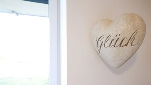 Sydämenmuotoinen kivi, johon on kaiverrettu sana »Glück», on kiinnitetty seinään.
