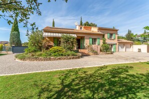 Une maison à deux étages avec une allée en gravier et une bordure en pierre.