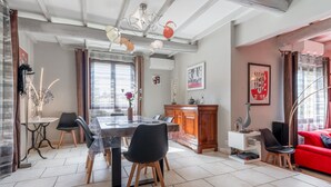Un espace repas comprenant une table, des chaises et un lustre.