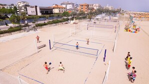 A beach volleyball court with net, sand, and players. - Friendly Mobile Home in Rimini Family Village (Rimini)