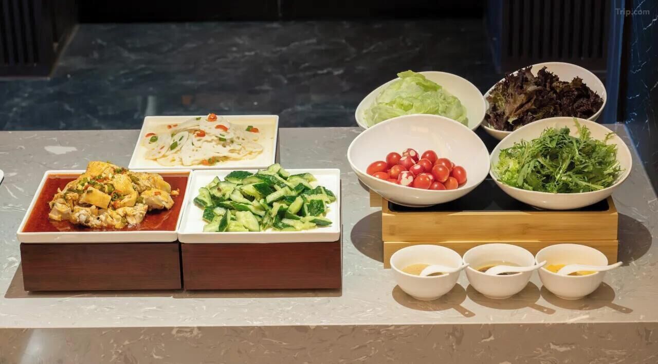 A buffet table with various dishes and side dishes.