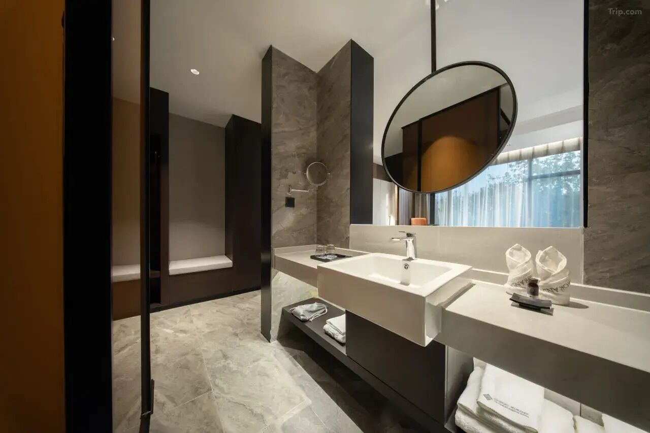 Un baño moderno con dos lavamanos, un espejo grande y una zona de ducha.