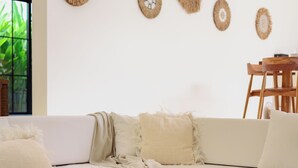 Ein modernes Wohnzimmer mit einem weißen Sofa, einem runden Couchtisch und Wanddekoration.