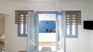 Ένα δωμάτιο με θέα στη θάλασσα, μια πόρτα και μια τηλεόραση στον τοίχο.