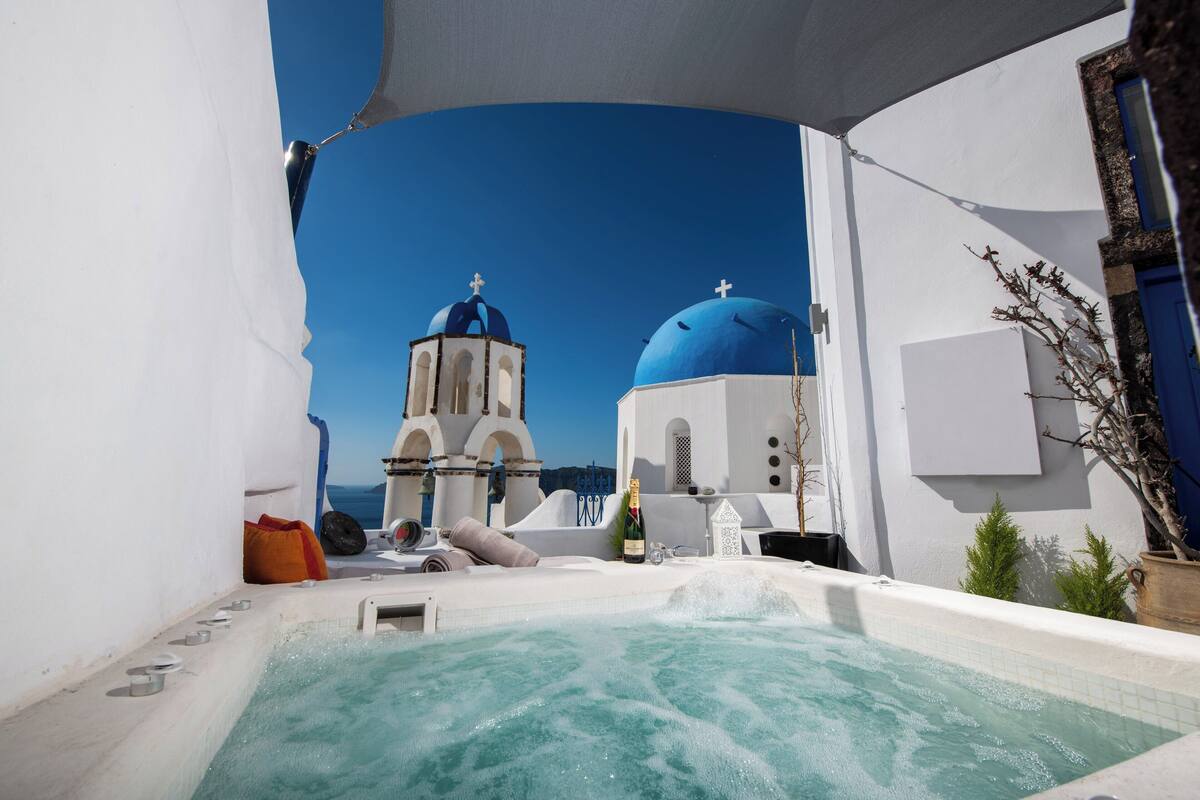 Un bain à remous offrant une vue dégagée sur un bâtiment doté de coupoles bleues et d’un clocher.