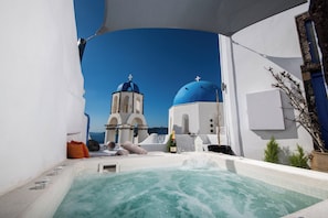 Ein Whirlpool mit Blick auf ein weißes Gebäude mit blauen Kuppeln und einem Glockenturm.