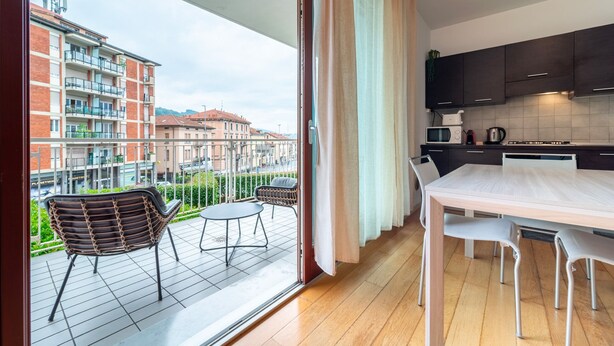 A modern apartment with a balcony, a dining area, and a kitchen. - Como Modern Bellinzona (Como)