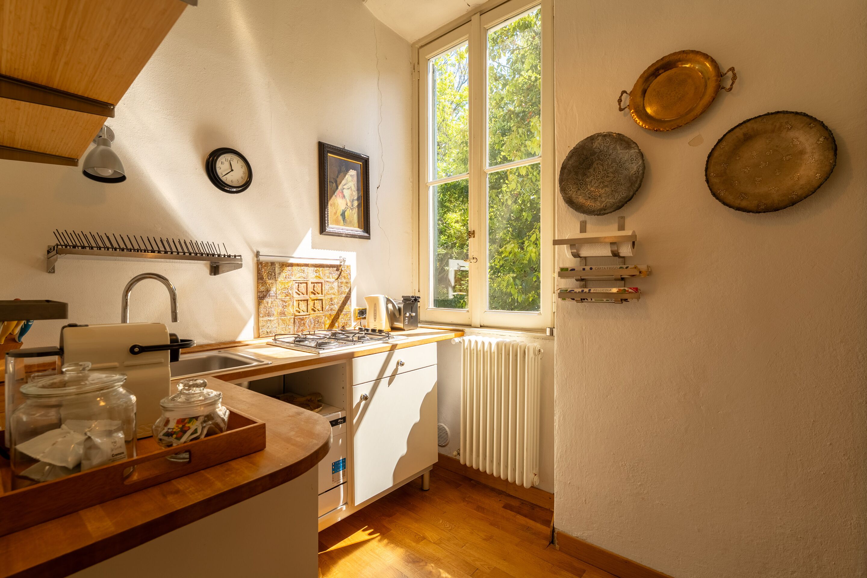 Eine Küche mit Fenster, Spüle, Herd und einer Arbeitsplatte mit Gläsern.