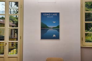 Una obra de arte enmarco titulada "Lago Como Bellagio" en una pared.