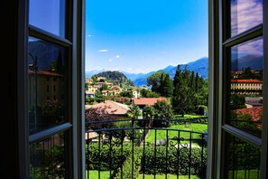 A view from a window overlooking a town with mountains in the background.