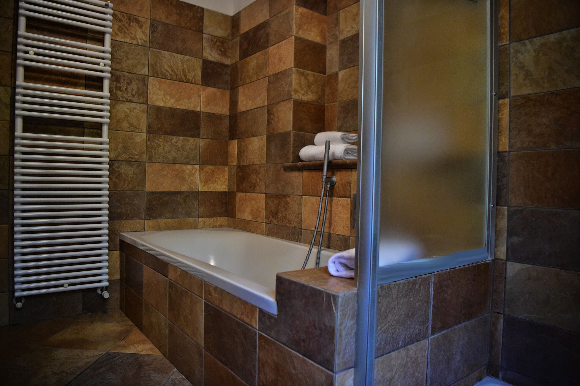 Une salle de bain avec une baignoire, une douche et un porte-serviettes.