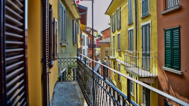 Un estrecho callejón entre edificios con balcones y barandillas.