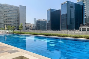 Ein Schwimmbecken mit freiem Blick auf moderne Gebäude im Hintergrund.