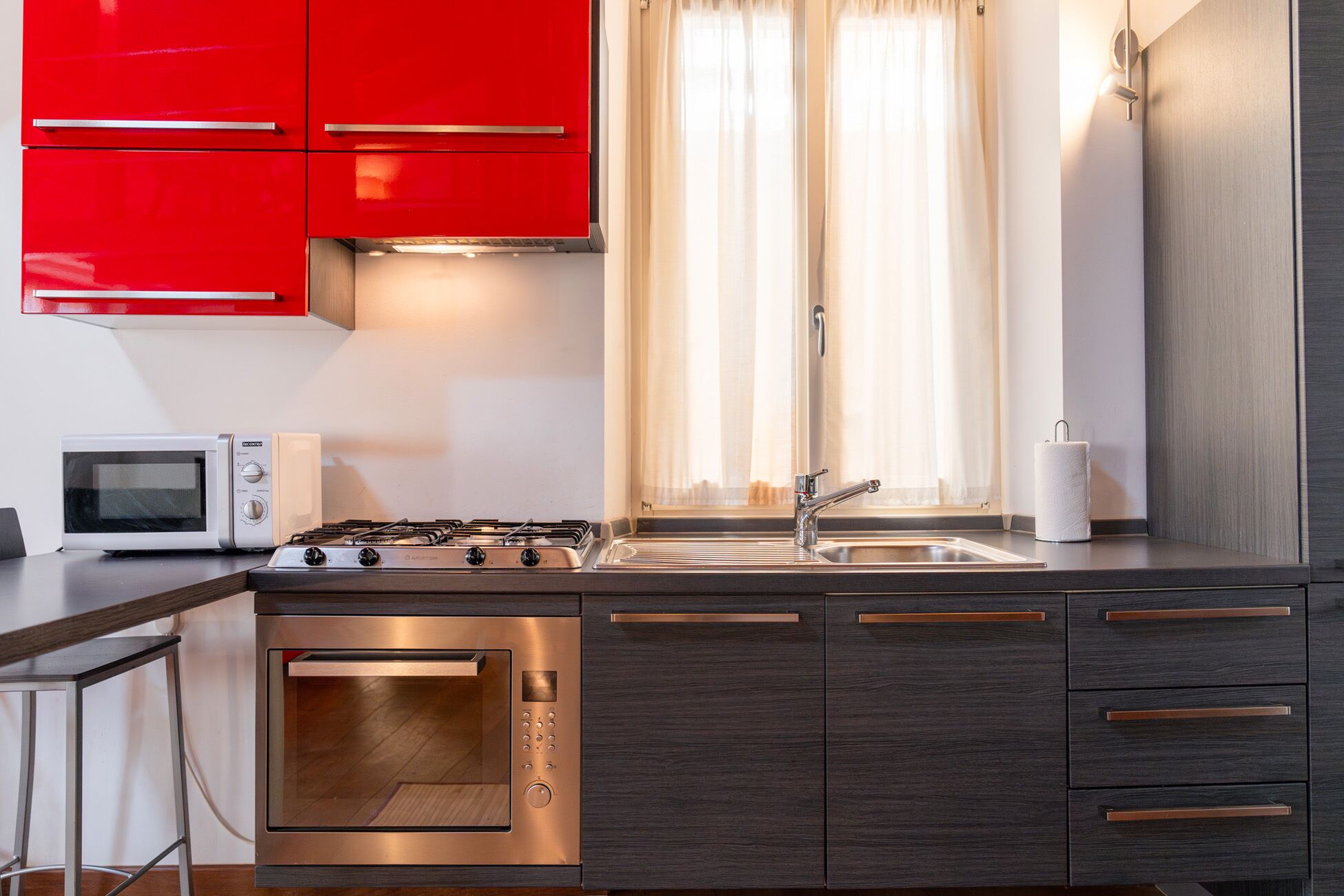 Una cocina moderna con estufa a gas, microondas y fregadero.