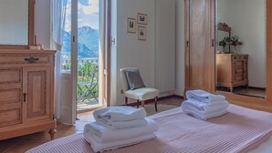 A hotel room with a balcony, wooden furniture, and a view of mountains.