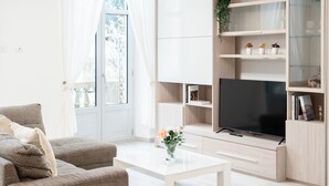 Ein modernes Wohnzimmer mit einer Couch, einem Couchtisch, einem Fernseher und eingebauten Regalen.