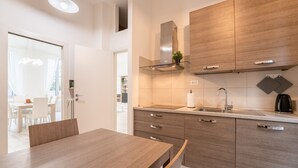Eine moderne Küche mit Holzausstattung, einer Edelstahl-Dunstabzugshaube und einer eingebauten Spüle.