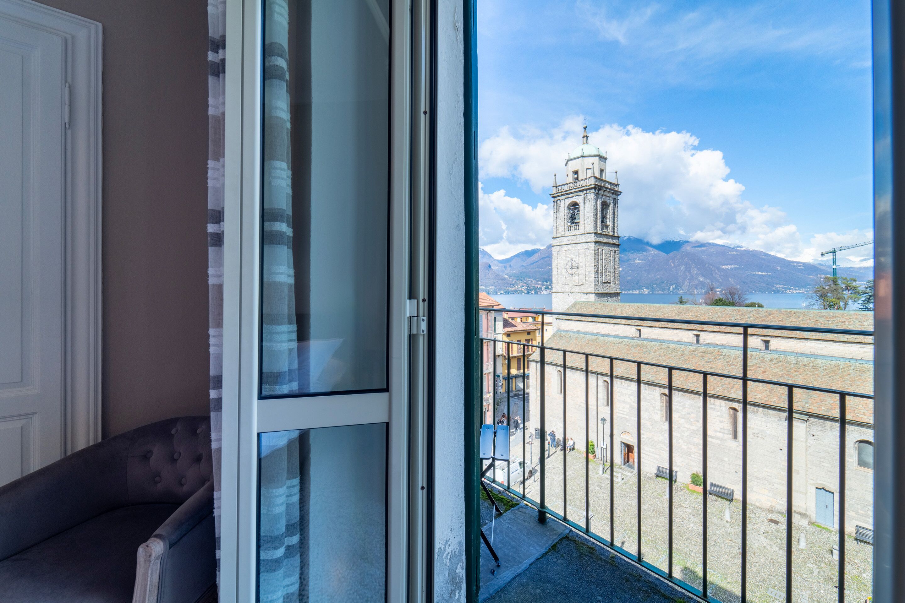 A room with a view of a historic tower and mountains.