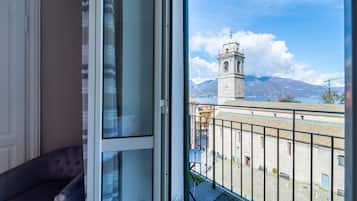 A room with a view of a historic tower and mountains.