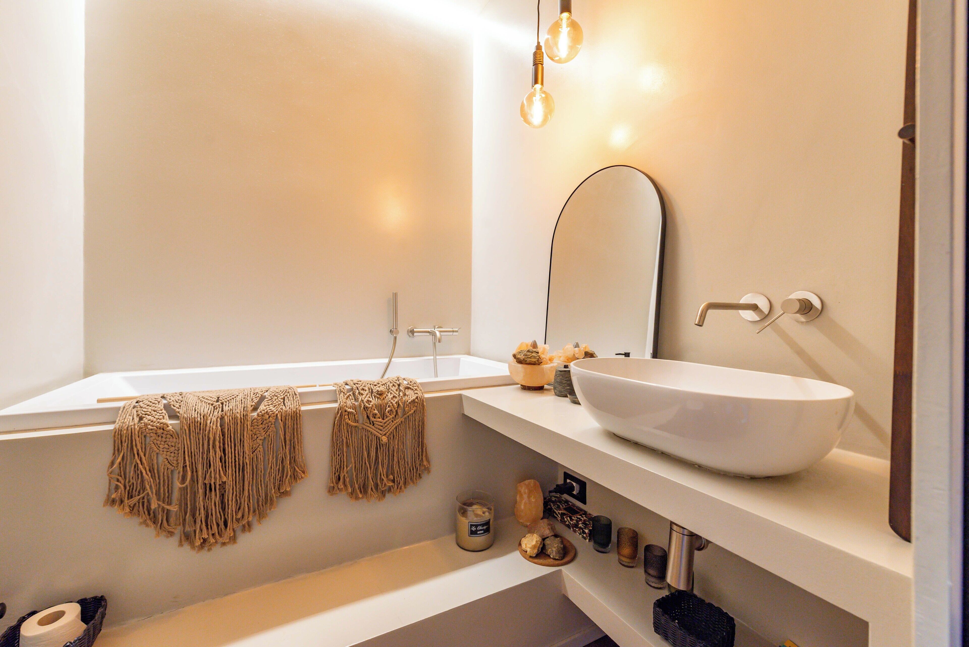 Un baño moderno con una bañera independiente, un espejo grande y un lavabo sobre encimera.