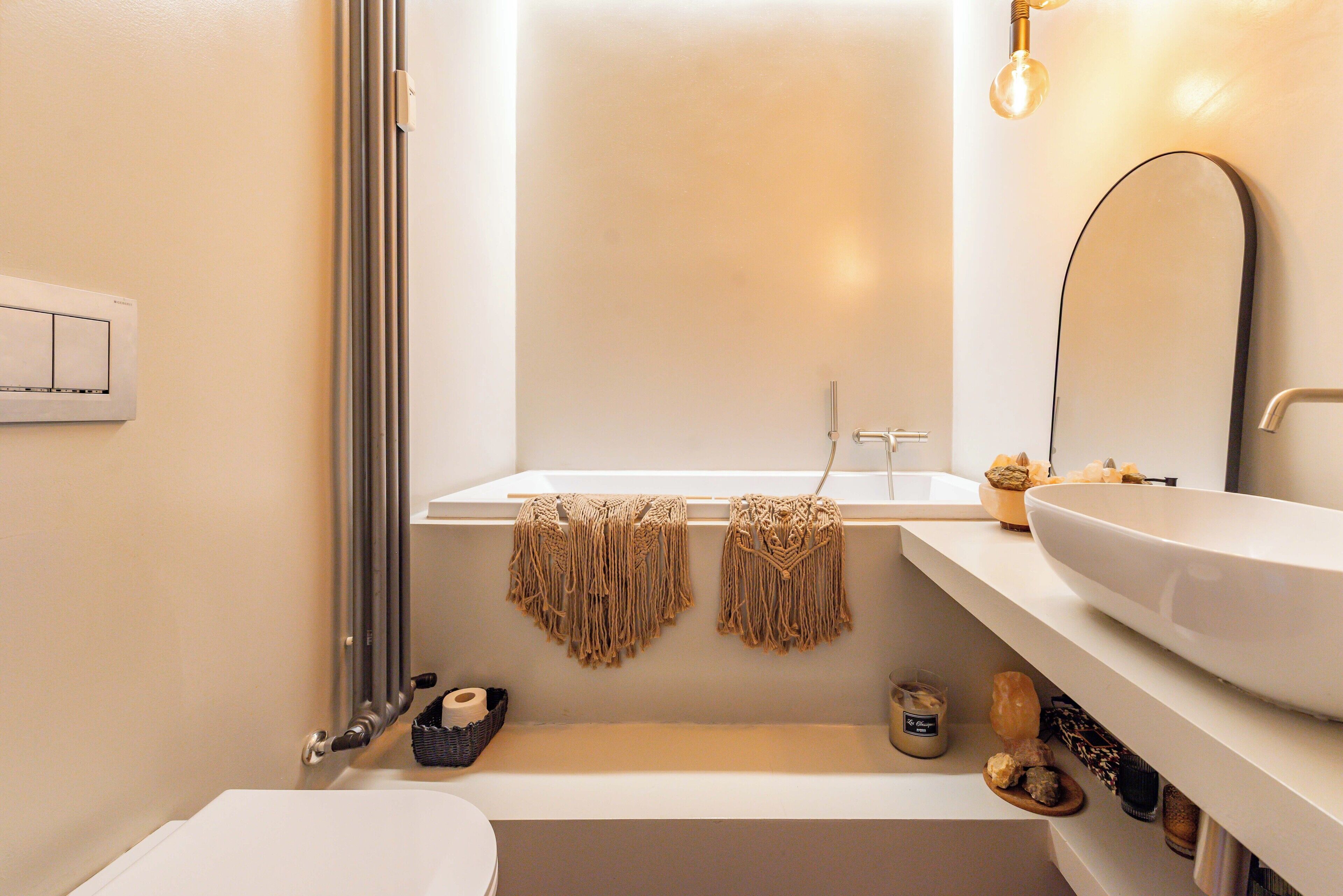 A bathroom with a bathtub, a toilet, a sink, and a mirror.