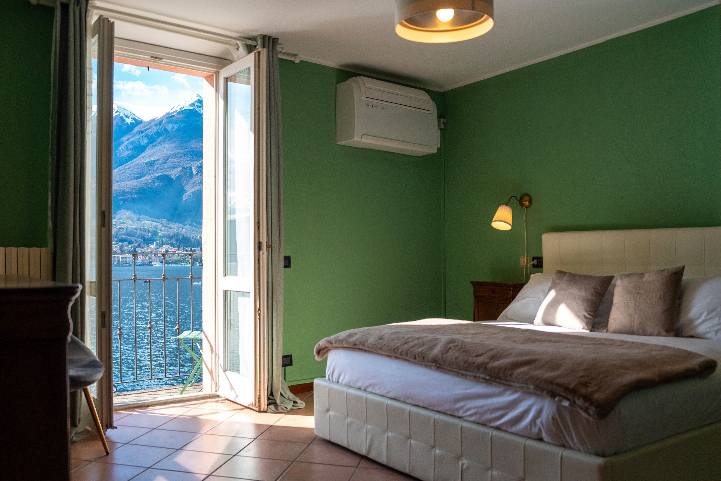 Ein Schlafzimmer mit Bett, einem Fenster mit Bergblick und einer Klimaanlage.