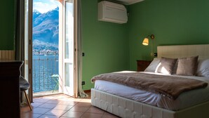 Een slaapkamer met een bed, een raam met uitzicht op bergen en een airconditioning.