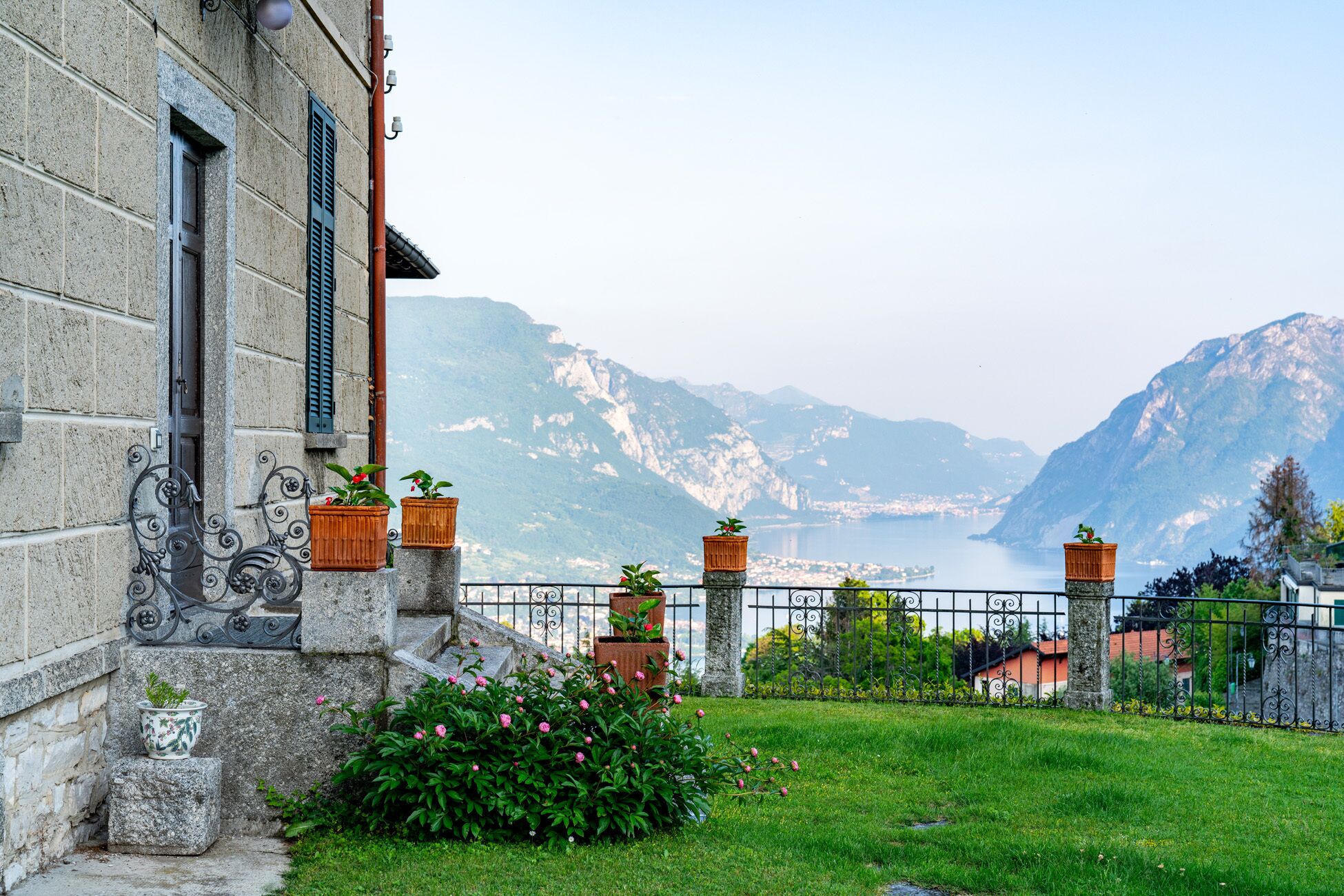 Un bâtiment en pierre doté d’un balcon donnant sur un lac de montagne.