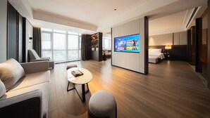 A modern hotel room with a large TV, a sofa, a coffee table, and a bed. - Giorgio Morandi Hotel - Bazhou (Langfang)