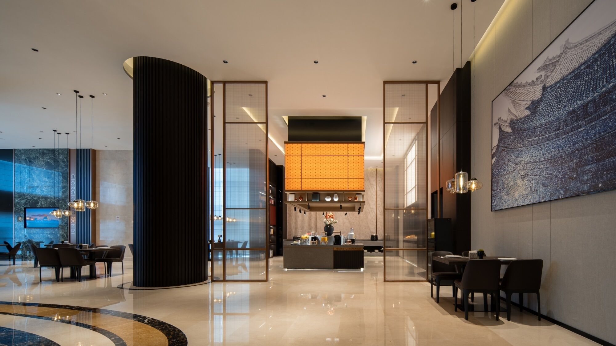 Un hall d’hôtel moderne avec un comptoir d’accueil, un espace salon et une grande œuvre d’art accrochée au mur.